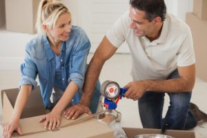 portrait-of-a-smiling-couple-packing-boxes